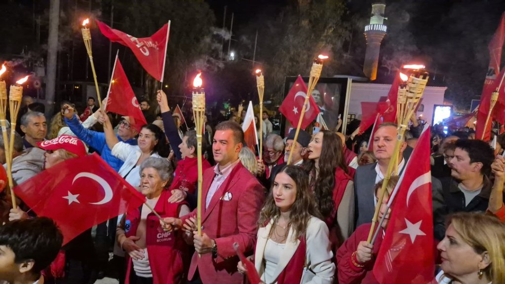 Türk bayraklarıyla ve meşalelerle bir araya gelen kalabalık bir grup, coşkulu bir etkinlikte yer alıyor.
